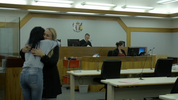 Image of Judge Hastings in SSC; PDS lawyer embraces defendant.