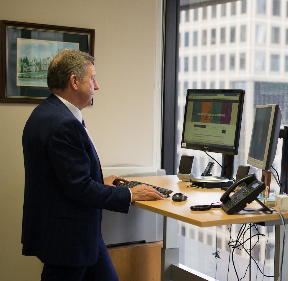 Image of Judge Fraser at a standing desk looking at the District Court website on the computer screen.
