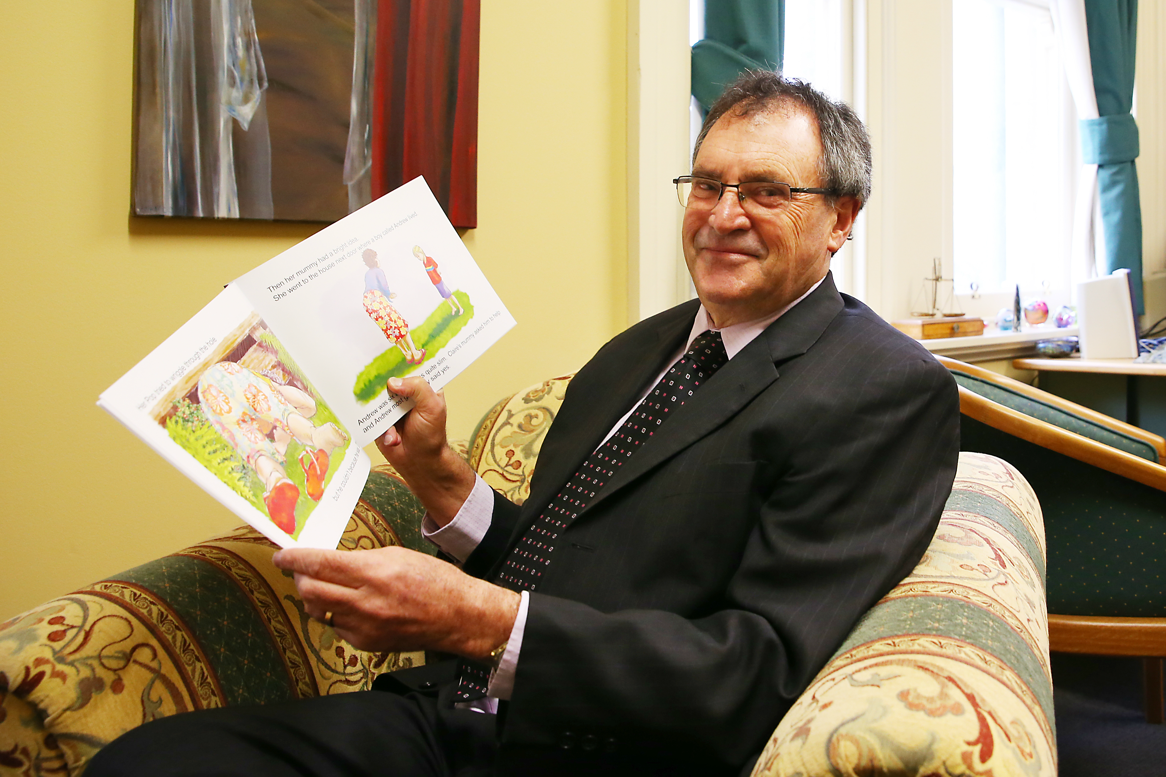 Image of Judge Murfitt with his children's book Claire and the Weka.