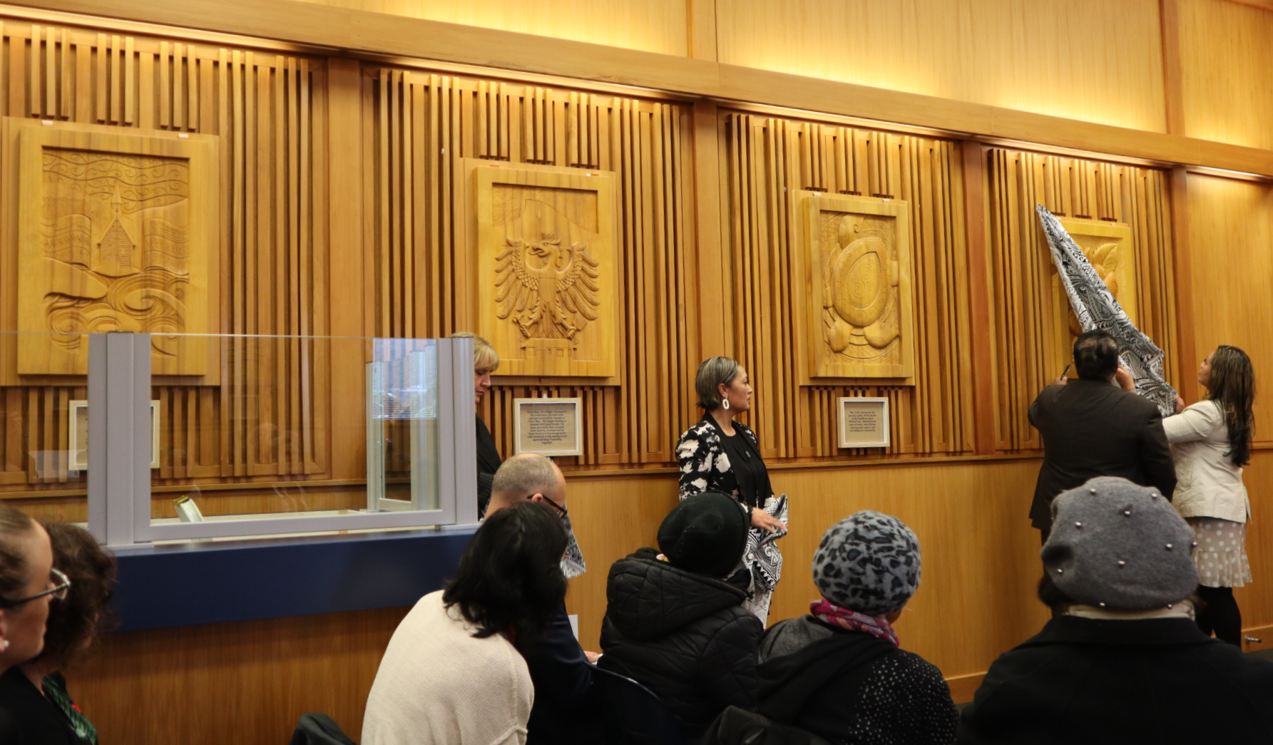 Image of unveiling of a panel in the set of carved panels by local carer Hermann Salzmann.